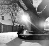 Reprofotografi.
Vinterkväll, vid gamla eken i Olins gränd, 1945.
