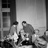 Skara Lottakår.
25-årsjubileum 1954. Lottachefen Anna Carlsson uppvaktas av hemvärnets Helge Björnberg, i förgrunden biskop Rudberg.