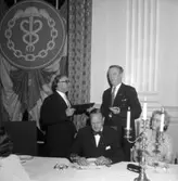 Skara Köpmannaförening.
50-årsjubileet 20/9 1958 på Skara Stadshotell. Skaraordföranden Fritz Bergsten gratuleras av Axel V. Larsson, längst till höger Svea Granqvist, Skara.