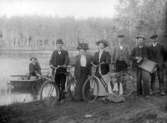 MÄN OCH KVINNOR VID EN SJÖ MED CYKLAR OCH DRAGSPEL. MANNEN MED DRAGSPELET ÄR  JULIUS PERSSON.