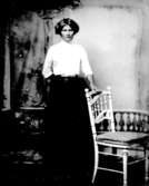 Ateljé. Dam vid stol.Fotograf: Ellen Kock? Axel Lundbäck m.fl.Gullspångssamlingen.Bilder från Gullspång med omnejd.