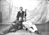 Ateljé. 
Tre herrar, en med fiol, två liggande på golvet.

Fotograf:
Ellen Kock? Axel Lundbäck m.fl.
Gullspångssamlingen.
Bilder från Gullspång med omnejd.