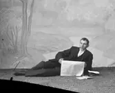 Ateljé.
Liggande tidningsläsande herre.
Fotograf: Ellen Kock? Axel Lundbäck m.fl.
Gullspångssamlingen.
Bilder från Gullspång med omnejd.