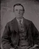 Ung man iklädd slips, väst och kavaj.