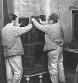 Skara, kv. Herrgården, Kråks herrgård. Östra flygeln. Kakelugnsmakaren Hjoberg  från Frändefors, sätter upp kakelugn i biblioteket.