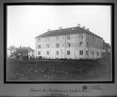 Huset byggdes 1915-16.
14 lägenheter Ã¡ 1 rum o kök
2 lägenheter Ã¡ 2 rum o kök
1 butikslägenhet
På skylten står: Speceri o Matvaruaffär.
