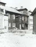 En innergård. Byggnaden har träfasad och en takkupa.