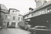 Gårdsfasad, innergård med lastbil och bil, Kvarnholmen väster om Västra Sjögatan. Bilderna är tagna inom ramen för Kalmar kommuns inventering av Kvarnholmens bebyggelse 1970-1971 och skänkta till länsmuseet.