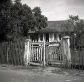 En stuga med en trägrind i förgrunden i Figeholm.