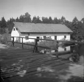 Bränneriet vid ett vattendrag och en brygga i Helgerum.