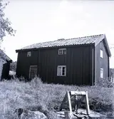 Boningshus med en brunn i förgrunden.