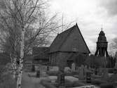 En klockstapel, kyrkogård och kyrka. Djursdala kyrka.