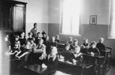 Klass 1 i ett klassrum på Västra skolan i Värnamo år 1926, läraren heter Anna Jakobsson.