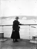 Ensam dam vid relingen på båt.
