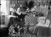 Kvinna vid bord med blommor, Östhammar, Uppland