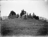 En man och tre kvinnor vid gärdesgården,  Östhammar, Uppland