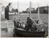 Befäl i samspråk med män i segelbåt.