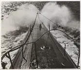 Bild tagen mot fören på en ubåt i full fart ytläge.