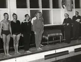 Män vid bassängkant.