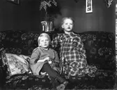 Interiör med två barn i en soffa.