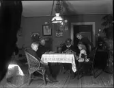 Två kvinnor och tre barn runt ett bord.