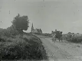 Naturbild. Ekipage med häst och vagn på väg mot Årstad kyrka.