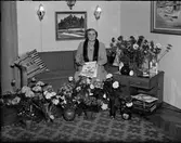 Kvinna i bostadsmiljö omgiven av blommor, Östhammar, Uppland