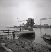 En strandad snipa och en motorjolle vid varvet i Kalmar. Snipan har troligen sköljts upp på stranden när fartyget gled av stapelbädden.