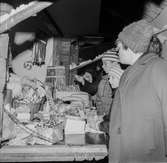 Julmarknad på Skansen. Personer tittar på varor vid julmarknadsstånd.