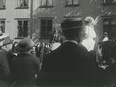 Karnevalståg med kvinnor på en stadsgata, eventuellt i Laholm. Finklädd publik kantar gatan. (Se även E5403.)