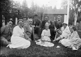 Ruben och Christiane Liljefors med barn och vänner har kaffepaus ute på gräsmattan på gården, sannolikt Svensgården, Dalarna
