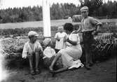 Christiane Liljefors med barnen Marit, Alf, Ingemar och Roland, vid flaggstång ute på gården, sannolikt Svensgården, Dalarna