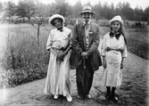 Sannolikt Alf, Roland och Ingemar Liljefors, utklädda som vuxna, står ute på gård, sannolikt Sverige
