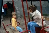 Barn och kvinna gungar