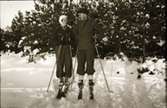 Vinterbild med Jenny och Karl Axel Lidberg (gården Albäck), förman på Jonsjö, poserar på skidor.