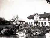 Marknadsdag i Floby centrum på 20-talet. T.v. Karl Anderssons hus och t.h. ett affärshus med speceributik i vänstra delen och järnaffär i högra. Detta hus rullades sedan ner till gatan och inrymde ICA-butiken.