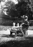 Christiane Liljefors mor Pauline Egelind Pedersen sitter ute i trädgård med Roland och Alf Liljefors, sannolikt i Norge omkring 1905