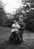 Christiane Liljefors mor Pauline Egelind Pedersen, sannolikt med sitt barnbarn Roland Liljefors, sitter ute i trädgård, i Norge omkring 1903-1904