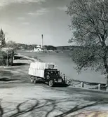 Lastbil på väg med frakt i Gustavsbergs hamn. Kattholmen syns i bakgrunden.<br>