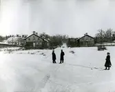 Vy mot husen på Värmdögatan. Enligt uppgift är det fjärdingsman Lundin och Oscar Wadström som möts på vägen.
Personer: Lundin, Oscar Wadström