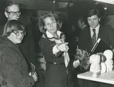 Interiör från utställningen Konstnärer från Gustavsberg på Illums Bolighus, Köpenhamn.
Personer: Ambassadörsfru Hagen i mitten, Ingemar Isakssson t.h. och Arthur Hald från Gustavsbergs Fabriker, t.v. okänd person