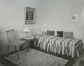 Interiörbild, sovrum. Sannolikt Grindstugärde från utställningen Så ska vi haÂ´t  med fyra möblerade lägenheter arrangerad av arkitekt Olof Thunström och Svenska Slöjdföreningen.