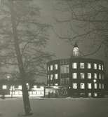 Exteriörbild. Kommunalhuset, Runda huset. Kväll i vintertid, i bakgrunden Domus.