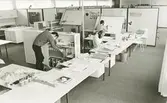 Interiör. Tekniskt center eller i folkmun kallat Glashuset, byggt 1971.
Personer: T. v. Tilman Fuch projektledare, i mitten Jan-Olof Landgren formgivare och t.h. vid ritbordet,  projektledare Rolf Ling.