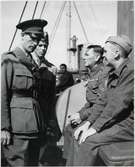 På bilden ses major, tillika byråchef vid järnvägsstyrelsens militärbyrå, Carl von Horn,  i samspråk med brittiska krigsfångar ombord på S/S Drottning Victoria. Han erhöll 1958 en hög tjänst inom Förenta Nationerna.