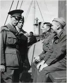 På bilden ses major, tillika byråchef vid järnvägsstyrelsens militärbyrå, Carl von Horn,  i samspråk med brittiska krigsfångar ombord på S/S Drottning Victoria. Han erhöll 1958 en hög tjänst inom Förenta Nationerna.