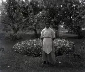 Edva Frödin vid en trädgård.
