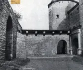 Tryck som visar del av yttre borggården på Kalmar slott med ingången till inre borggården till höger.