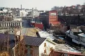 Kvarnbygatan österut, okänt årtal. I förgrunden: takåsar till byggnader vid Gamla Torget samt Götiska Förbundets friskola. Till vänster: Soabs industriområde. Till höger, uppifrån: 