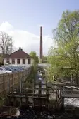 Byggnadsdokumentation av Papyrusskorstenens rivning 2015-05-08. Strax innan fallet. Vy från Forsebron över Mölndalsfallen som rinner genom hela industriområdet. Byggnaden till vänster var Papyrus gymnastiksal (Byggnad 217) på Norra Forsåkersgatan 2 B.